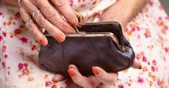 older woman holding change purse retirement savings